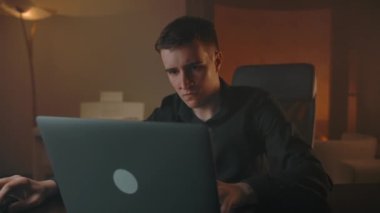 Adam dizüstü bilgisayarda oyunu kaybediyor ve mağlubiyetinden dolayı öfkeli..