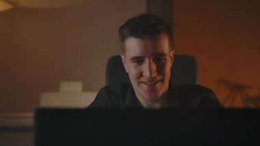 Dizüstü bilgisayarın arkasındaki genç oyuncu oyunu oynuyor ve kazanıyor.