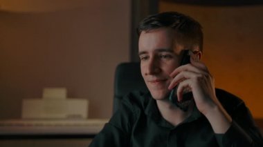 Evin içinde bir adam telefonda gülümsüyor.