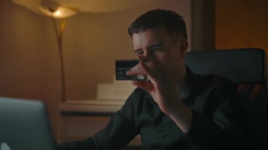 Çevrimiçi dükkanda plastik kartla online alışveriş yapan genç işadamı