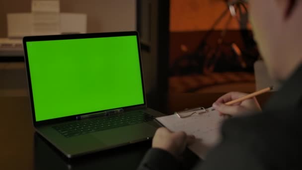 Mannelijke werknemer noteert gegevens van laptop — Stockvideo