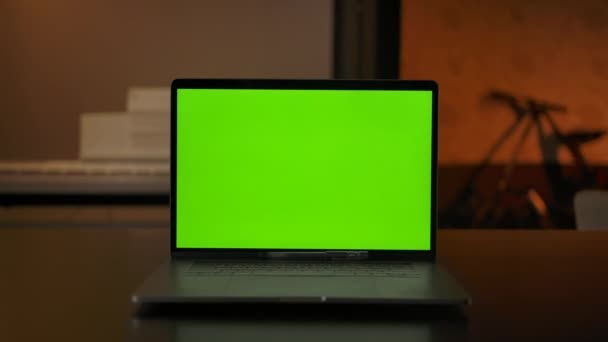 Laptop computer met groene chroma key screen staat op een bureau in de woonkamer — Stockvideo