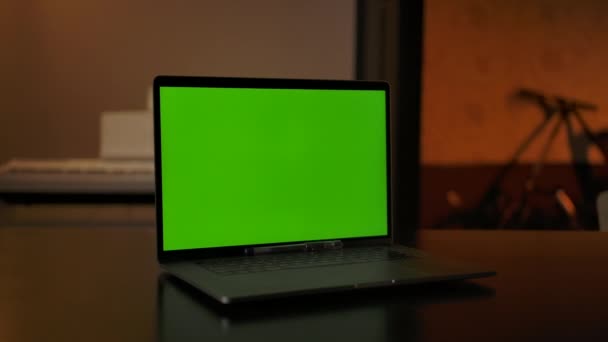 Grüner Chroma-Keyscreen am Laptop, der auf einem Schreibtisch im Wohnzimmer steht — Stockvideo