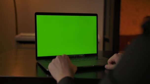 Hombre sin rostro saludando a sus colegas en la llamada en línea a través de ordenador portátil con chromakey — Vídeo de stock