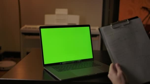 Het schrijven van wetenschappelijke notities achter groene scherm laptop thuis — Stockvideo