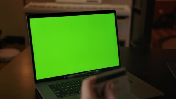 Dolly en la toma de la computadora portátil de pantalla verde y mans mano con tarjeta de crédito o débito — Vídeo de stock