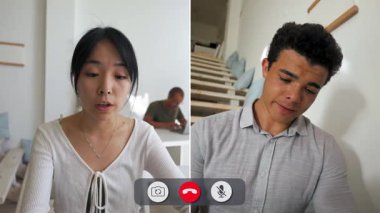 Bir adam çevrimiçi görüşme sırasında ekranının önünde oturuyor. Diğer taraftaki kadın konuşurken sıkılmış görünüyor. Farklı yerlerde gibi görünüyorlar..