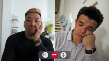 Bir adam çevrimiçi görüşme sırasında evde oturup sıkılmış görünüyor. O, başını elinde dinlendirirken arkadaşının konuşmasını dinler. Arkasında merdiven varken ortam rahat..