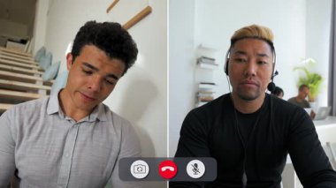 Bir adam çevrimiçi görüşme sırasında ekranın önünde oturuyor. Ekranına bakarken çevresinden sıkılmış ve dikkati dağılmış görünüyor..