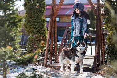 Ciddi bir kürk şapka ile bir Husky köpek kadında 