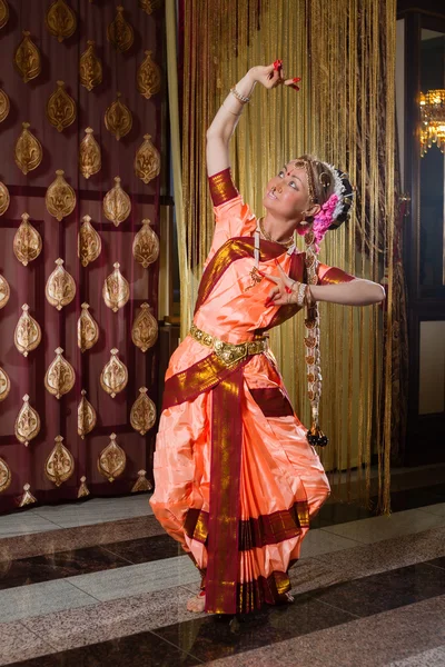 Beyaz kadın geleneksel Hint elbiseyle dans ediyor