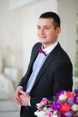 Damat standları yaslanmış, gülümseyen