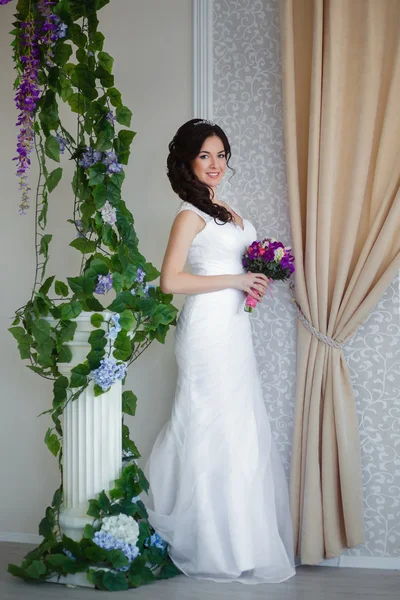 Bride dekat kolom dengan tanaman merambat berbunga — Stok Foto