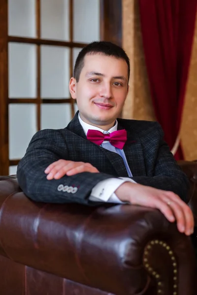 Bir deri koltuğunda oturmak portre damat