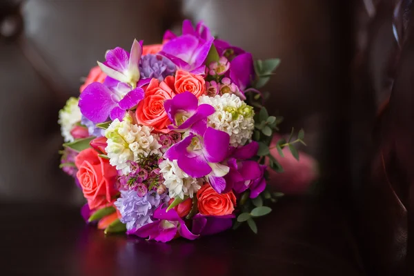 Purple bridal bouquet of the bride, on a brown background — Stock Photo, Image