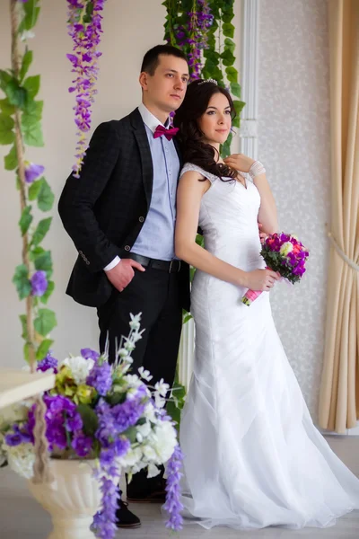 Bridegroom embraces the bride with his hand in his pocket — Stock Photo, Image