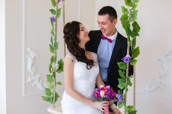 Just married play, bride sitting on a swing with the vine — Stock Photo, Image