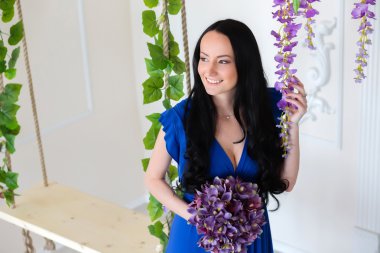 Salıncağın gülümseyen çiçekli mavi elbiseli kız