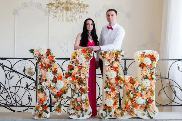 Couple near the huge letters of colors — Stock Photo, Image