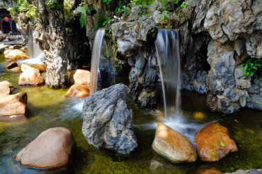 Parktaki dekoratif çeşme taşlarla dolu.                             