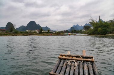 Yulong nehri, Yangshuo Çin 'deki Karst tepeleri arasında bambu tekne gezisi.                               