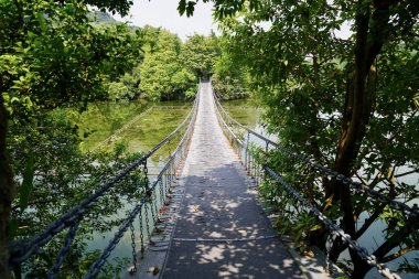 Parktaki nehrin üzerindeki asma köprü.                               