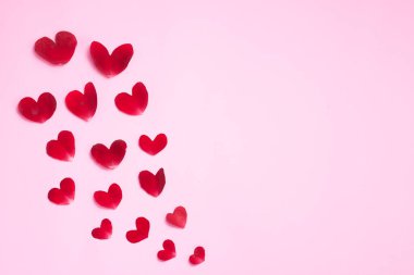 Gül yaprakları şeklinde pembe arka plan, gül, beyaz mumlar ve kağıt..