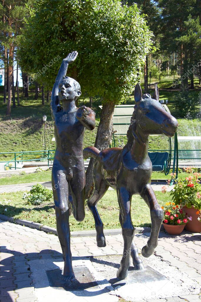 Beautiful sculpture of a boy with a horse in the Altai Mountains in Russia in the summer