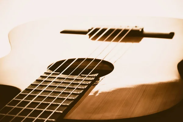 Müzik severler için. Tahta bir akustik gitarın farklı parçalarının yakın plan çekimi. Köprü, vücut, teller gibi.. 