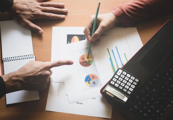  İş adamı ve iş kadını büroda. Finansal bir raporu analiz etmek ve beyaz bir kağıttaki finansal verilere işaret etmek. Beyin fırtınası.