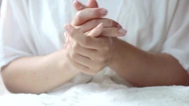 Genç beyaz kadın cilt bakımı için ellerini nemlendiriciyle ovalıyor. Ellerin cilt bakımı kavramı