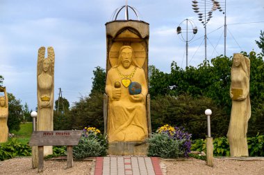 Eski bir ağacın kuru gövdesinden dini temalar üzerine stilize heykeller..