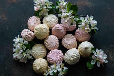 Lezzetli beyaz-pembe şekerlemeler ve bir elma ağacının çiçek açan dalı..