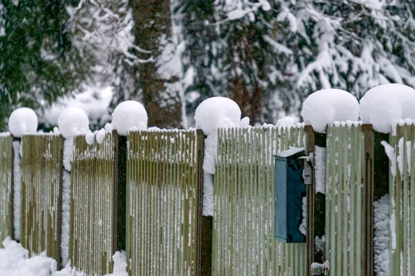 The fence posts are covered with white snow