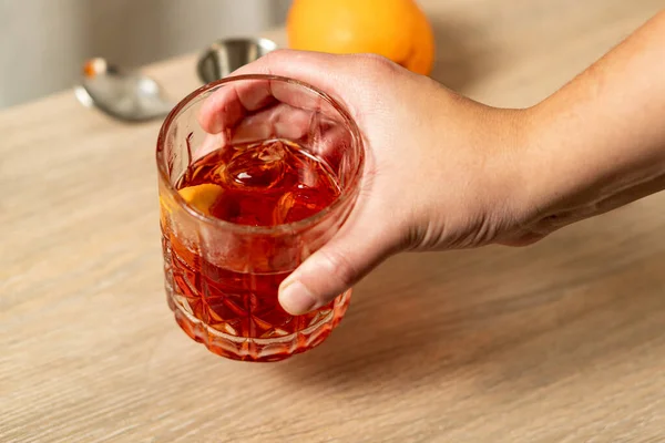 Close View Negroni Cocktail Being Lifted One Hand — Foto Stock