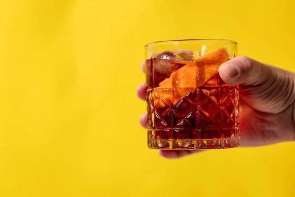 Negroni içkisinin sarı arka planda el ele tutuşmasını yakından izleyin..