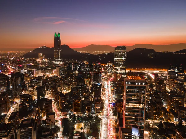 stock image Aerial view of a sunset in the financial center of Santiago de Chile with its buildings and streets illuminated and the mountains outlined in the background with air pollution.Aerial view of a sunset in Santiago de Chile with its buildings and street