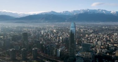 Santiago de Chile 'in arka planında karla kaplı And Dağları ile hava manzarası.