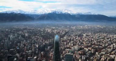 Santiago de Chile şehrinde kışın karlı sıradağların yörüngesine bakan hava manzarası..