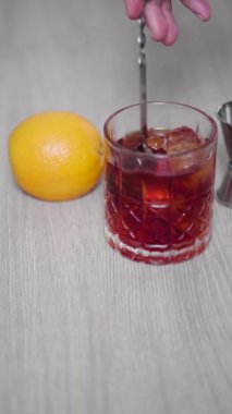 Karışık kaşıkla karıştırılan negroni kokteylinin yavaş hareketi.
