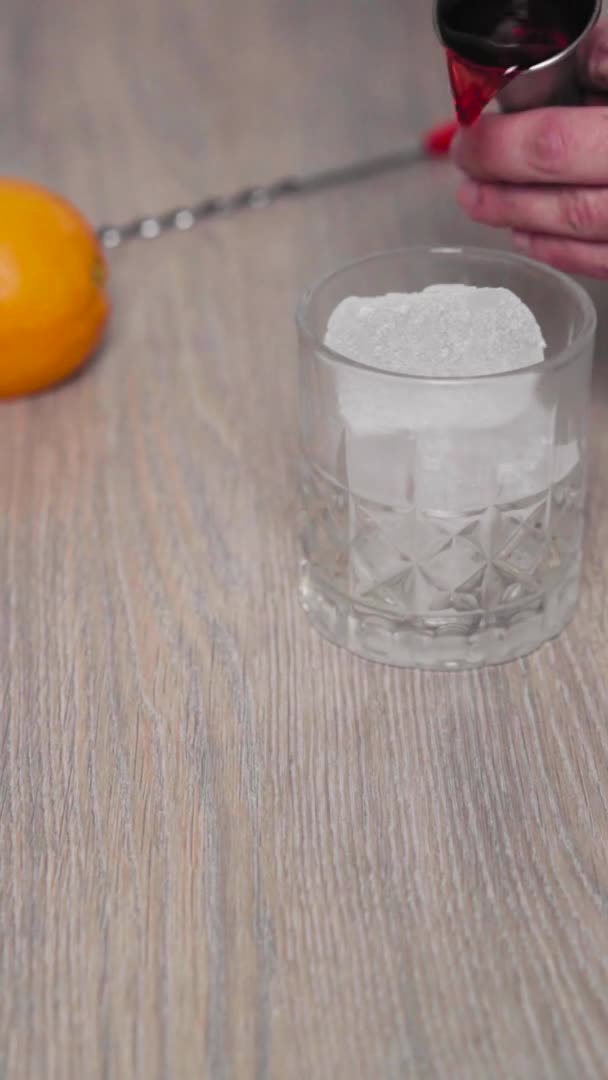 Slow Motion Short Glass Filled Ice While Pouring Red Alcoholic — Stock Video