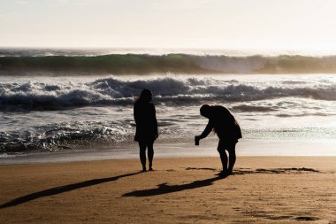 İki kızın kendi fotoğraflarını çektiği bir plaj tatili.