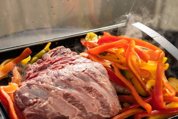 Izgarada et ve yanında kırmızı biber.