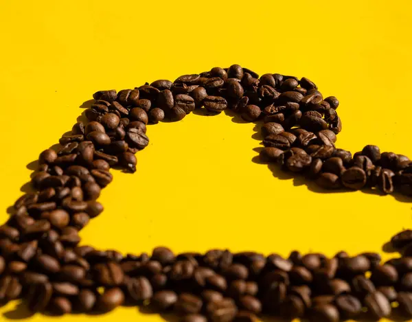 Sarı arka planda kahve çekirdekleri yakın plan.