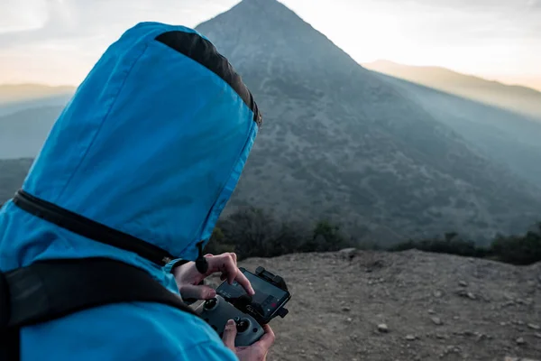 Yakın plan insansız hava aracı kontrolü. Arka planda günbatımı var.