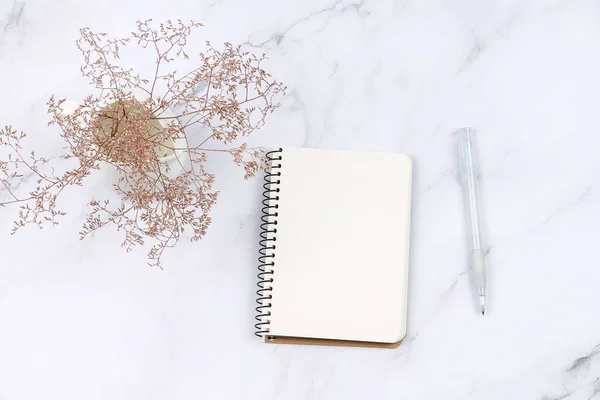 Not defterini, bitkiyi ve kalemi mermer yüzeyde aç. Notlar için boş sayfa.