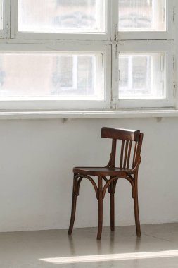 Boş bir sandalye güneşli bir pencerenin altında.. 