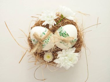 Yuvasında papatya çiçekleri olan ev yapımı Paskalya yumurtaları.