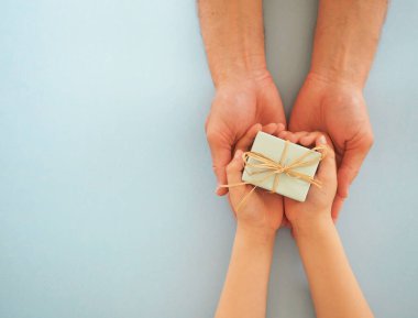 Baba ve oğlu bir hediye tutuyorlar.