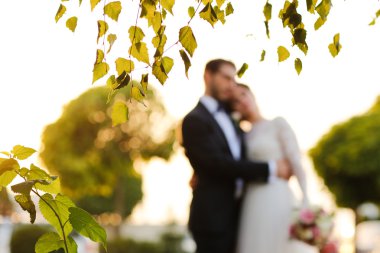 Neşeli gelin ve damat ile açık havada kucaklayan buket